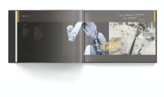 Jubiläumsbroschüre der DÜRR Group, letzte Doppelseite. Das Key Visuell zeigt einen modernen Roboter und Heinz Dürr, wie sie sich aus verschiedenen Zeiten ansehen.