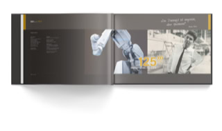 Jubiläumsbroschüre der DÜRR Group, letzte Doppelseite. Das Key Visuell zeigt einen modernen Roboter und Heinz Dürr, wie sie sich aus verschiedenen Zeiten ansehen.